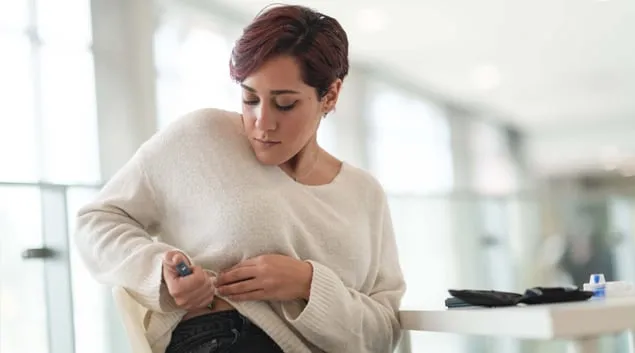 Person injecting herself with medicine Person injecting herself with medicine