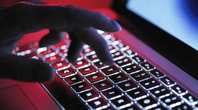 Hand typing at laptop keyboard