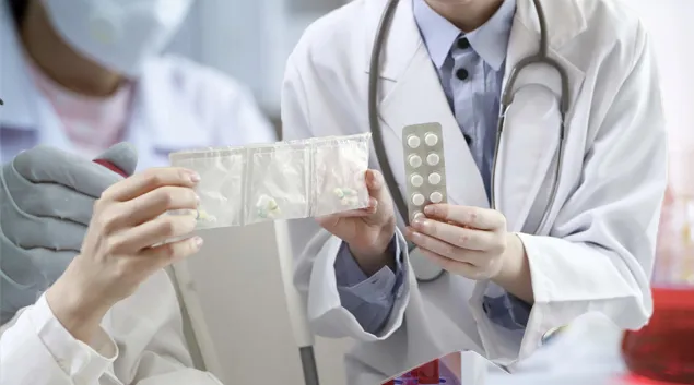 Clinicians exchanging pill packets