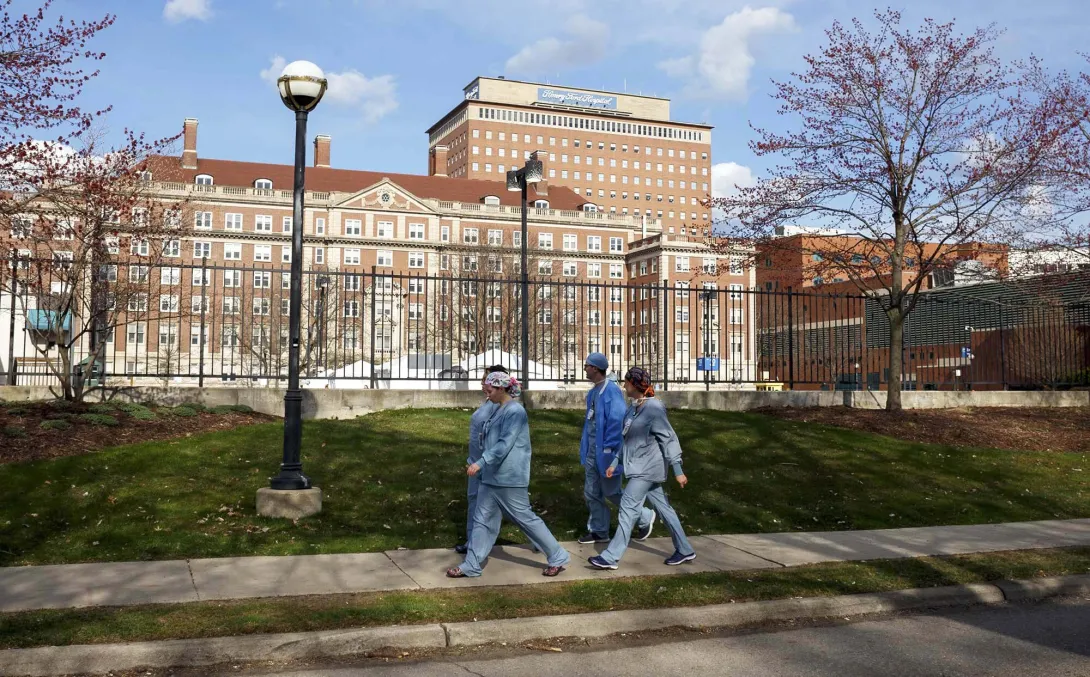 Workers walk past Henry Ford Health 