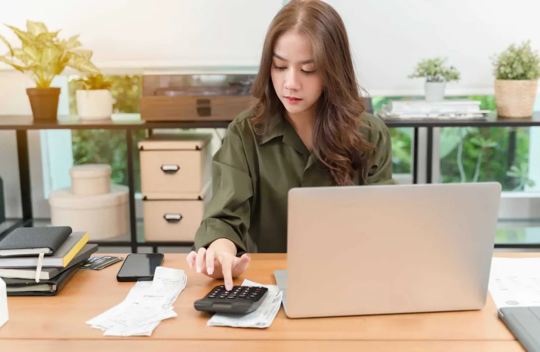 Person using a calculator and a computer