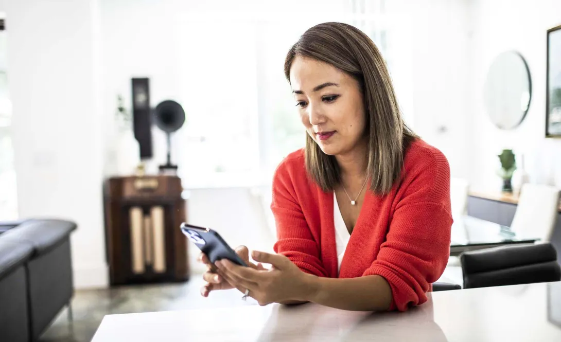Person at home desk using phone