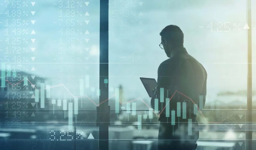 Business person using tablet over shifting stock market image