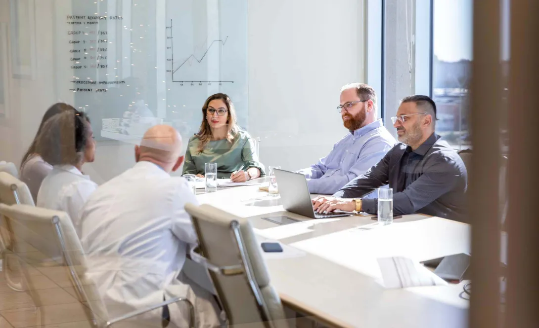 Colleagues meet in a conference room.
