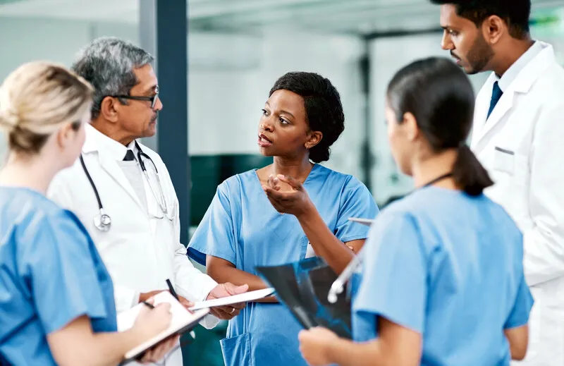 Healthcare professionals in discussion, standing in a circle