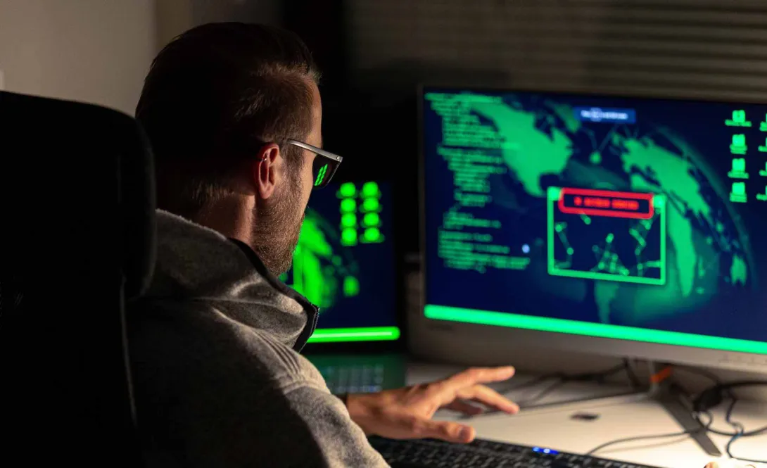 Hacker at dark keyboard.