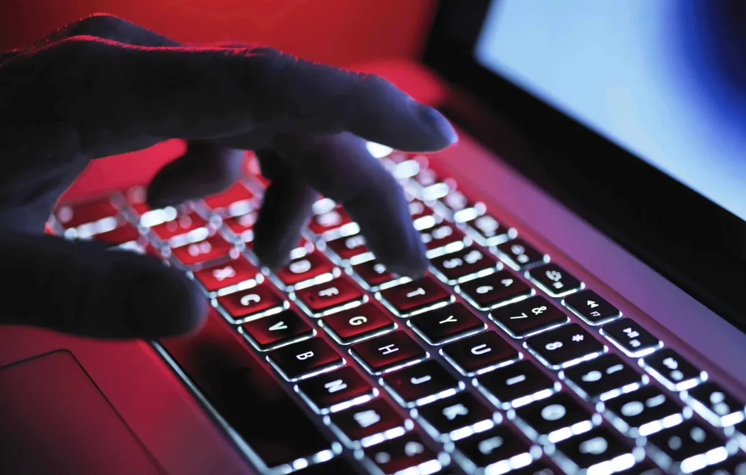 Hand typing on dark keyboard