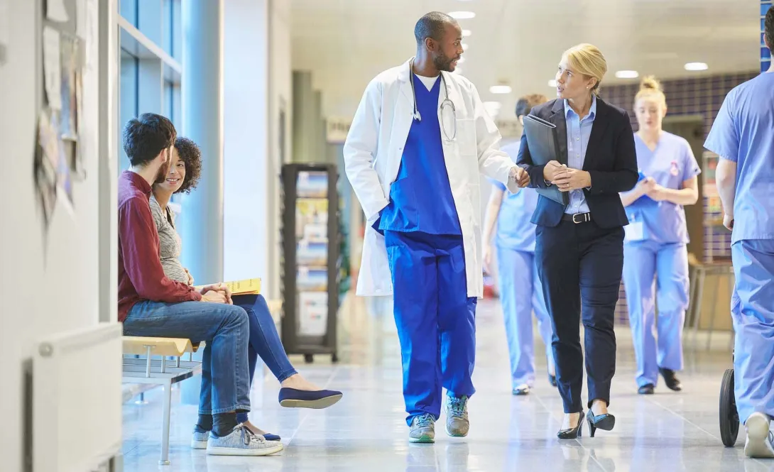 Physicians and others walking in hospital corridor