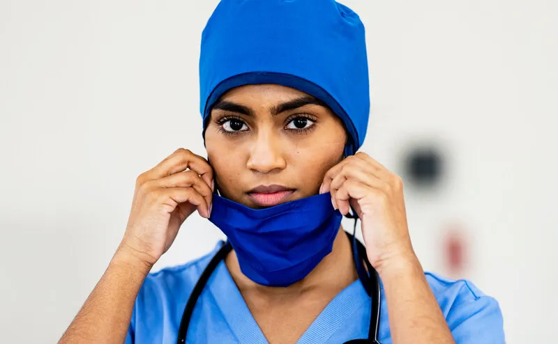 A healthcare professional wears a mask.