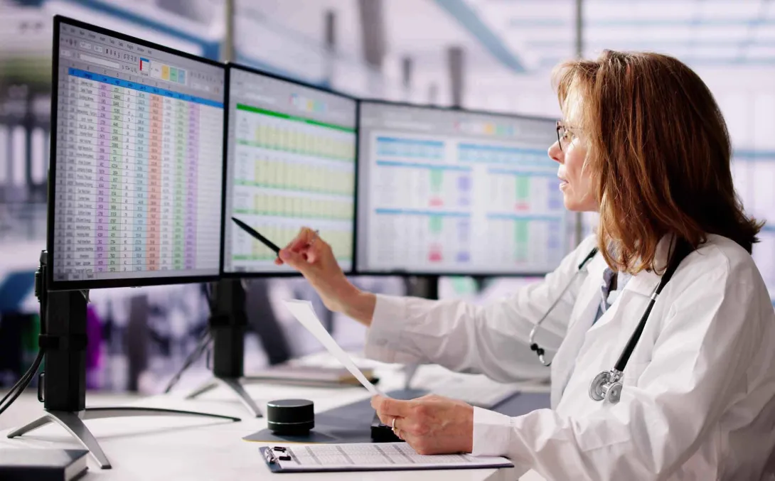 A clinician works in front of computer screens