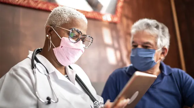 A medical visit with the professional holding a tablet