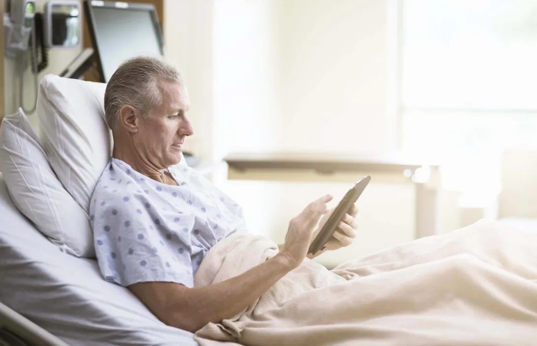Patient in bed with computer tablet