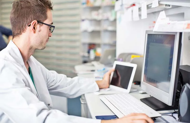 Pharmacist at computer screen