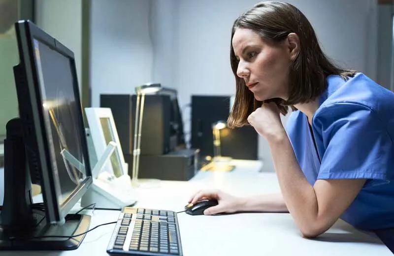 Healthcare professional looks at a computer screen