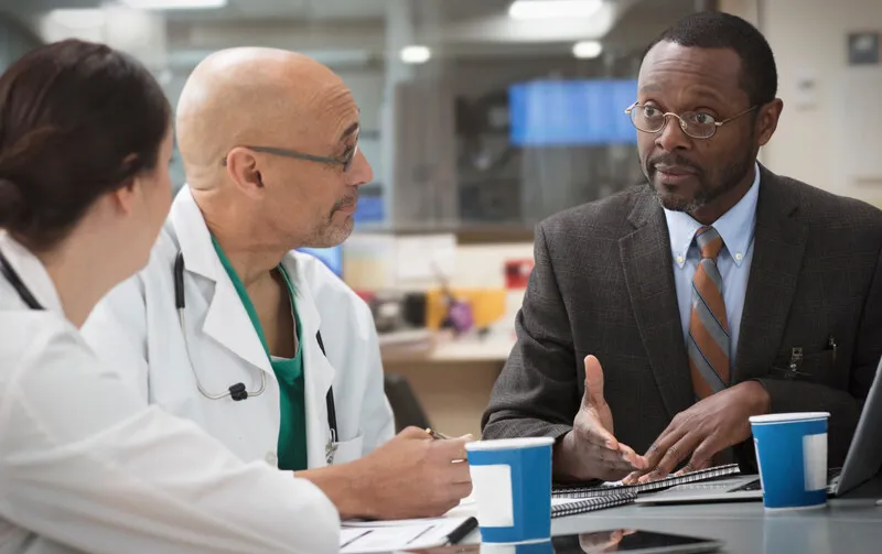 Hospital professionals and business person meet