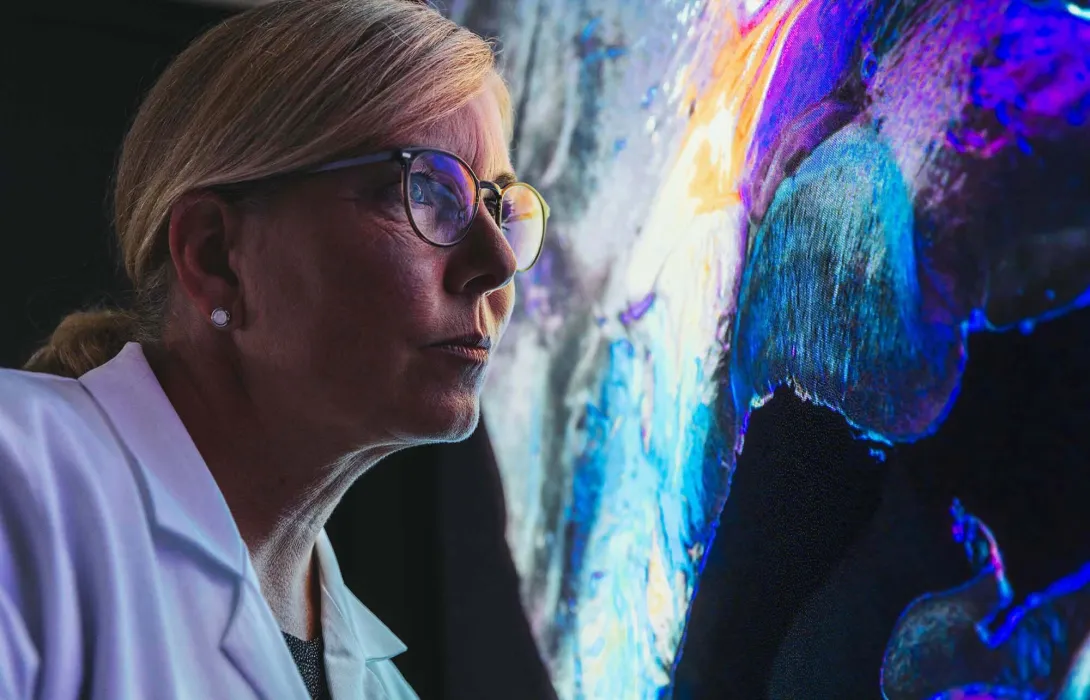 Person in lab coat with computer display