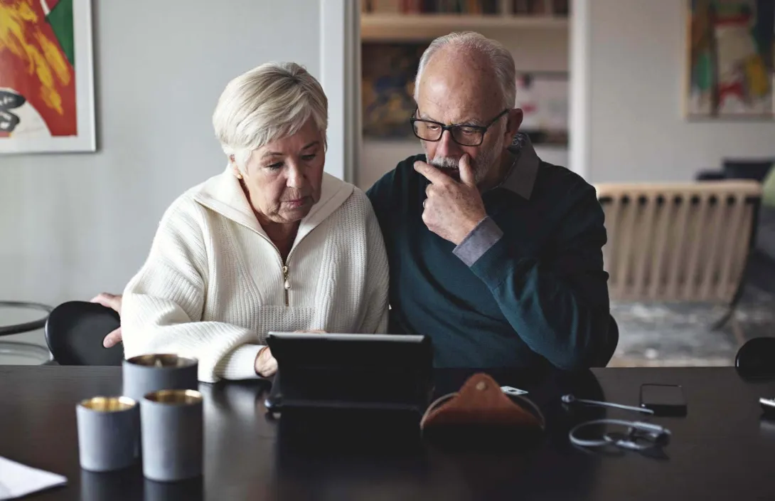 Two people search laptop for a Medicare Advantage plan