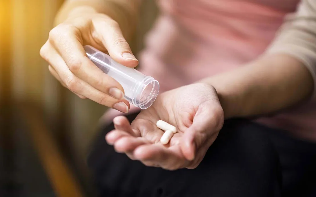 One hand dispenses pills into another
