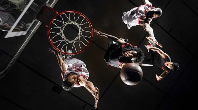 Basketball players driving toward the hoop