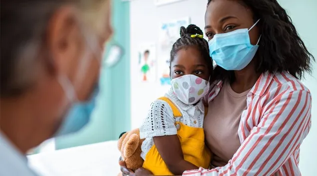 Mother holding child in doctor's office