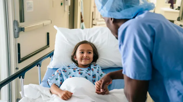 Adult by hospital bed holds child's hand