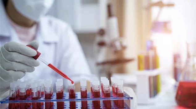 Lab worker filling test tubes with blood