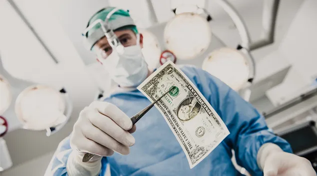 Person in PPE holding dollar bill with forceps