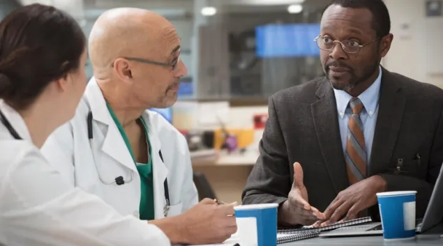 Business person meets with two health professionals