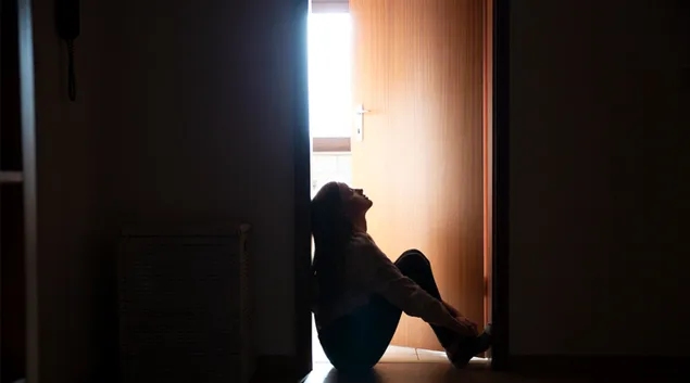 Person sitting on floor in a doorway