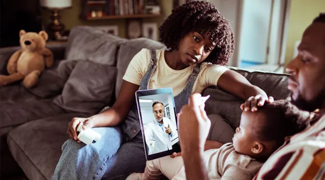 Person on sofa with child having a telehealth visit