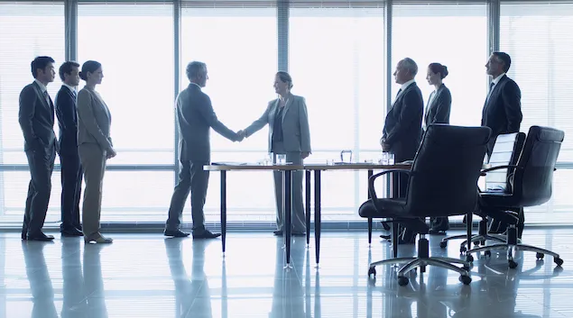 People shaking hands in a boardroom